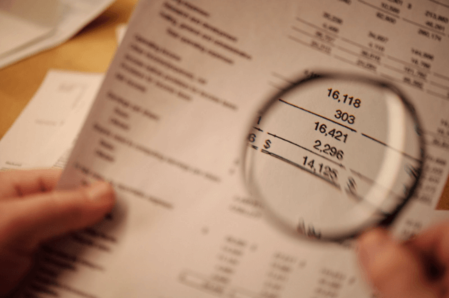magnifying glass on a financial report